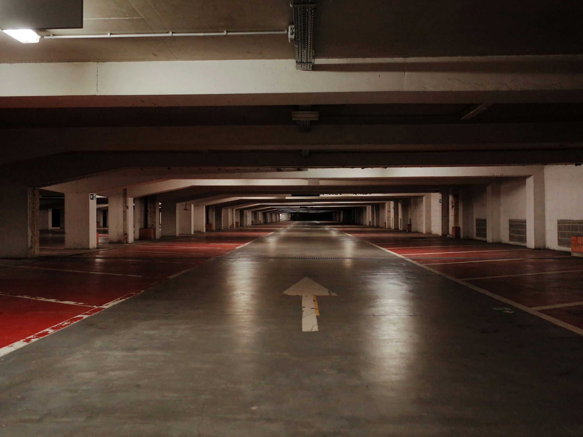 Empty underground parking garage with painted floor markings.