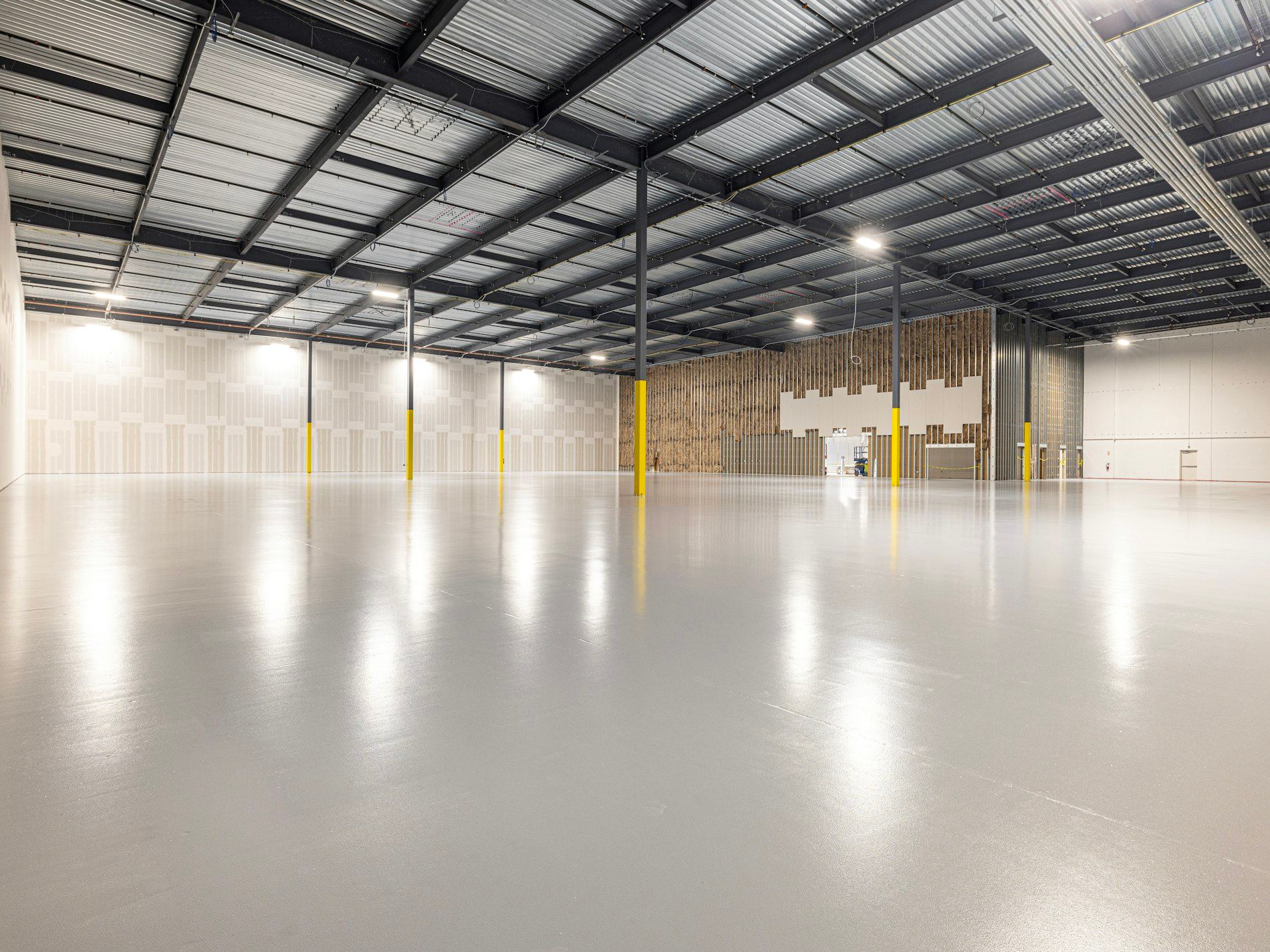 Empty warehouse with glossy polished resin floor and overhead lighting