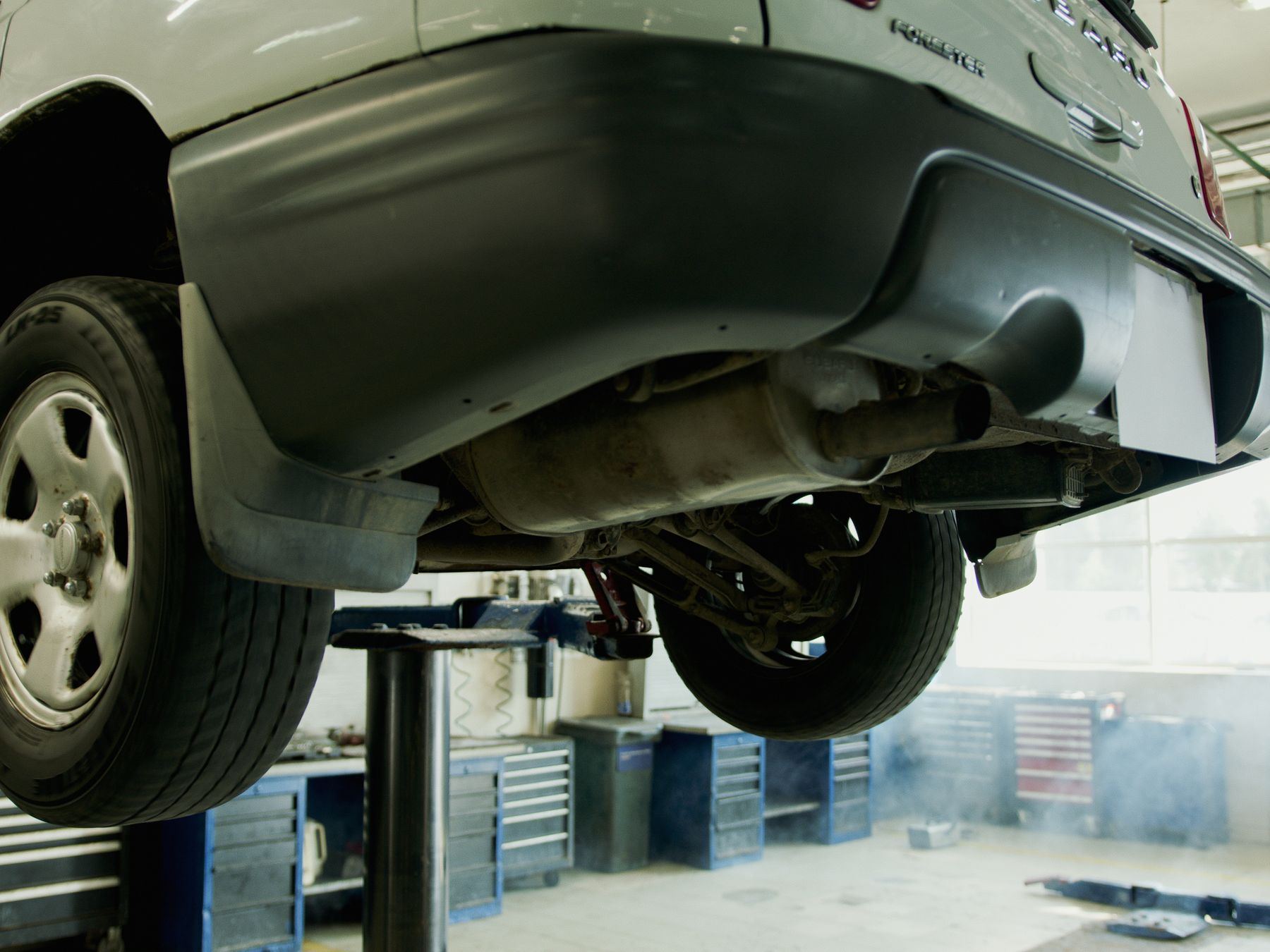 Car raised on a lift in a bright, clean automotive workshop.