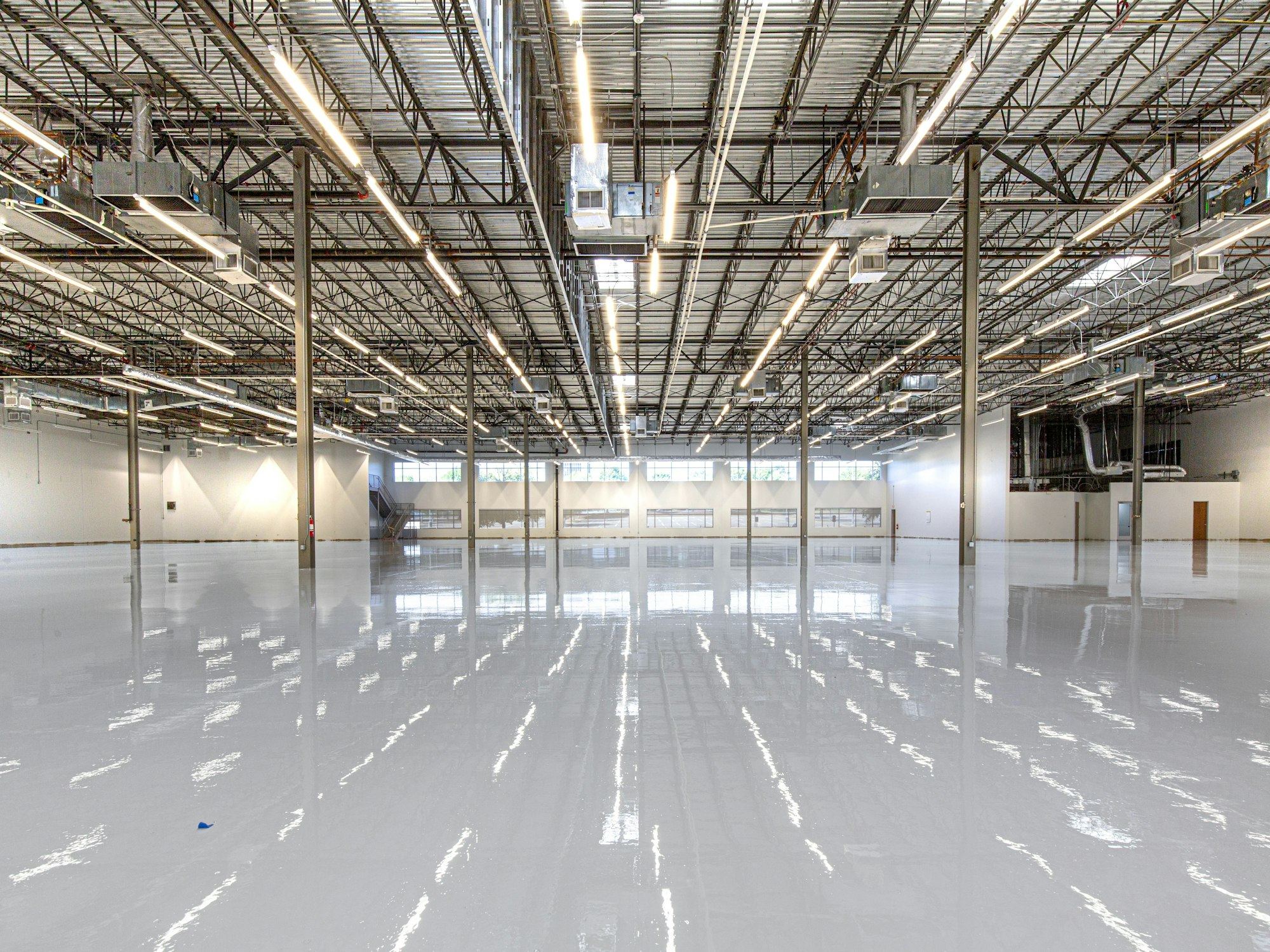 Shiny warehouse floor reflecting overhead industrial lighting